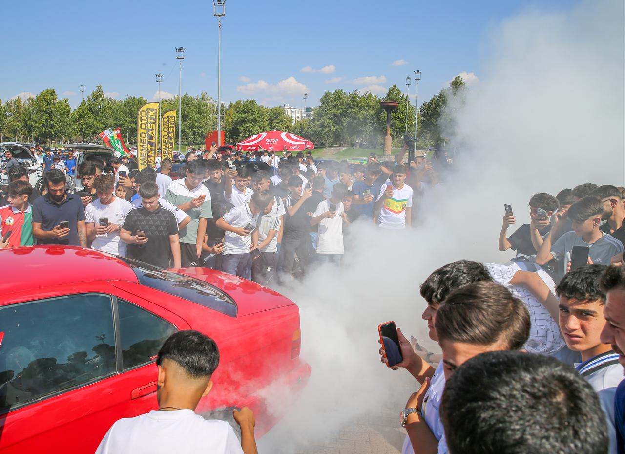 Visitors watch a modified car performance as smoke fills the area during an automobile festival in Diyarbakir, Türkiye, Sept. 20, 2026. (AA Photo)