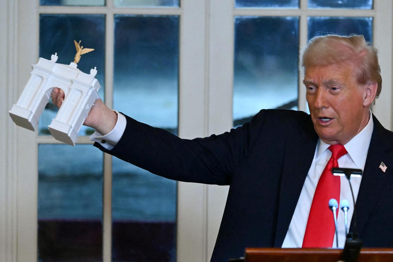 US President Donald Trump holds up a model for a proposed "Independence Arch" as he speaks during a dinner with ballroom donors in the East Room of the White House in Washington, DC on October 15, 2025. (AFP Photo)