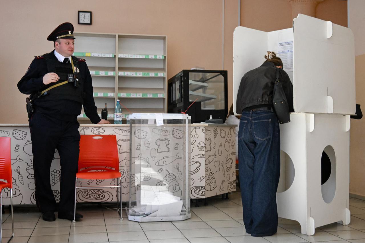 A policeman stands guard as people vote in Russia's parliamentary election at a polling station in Moscow on September 20, 2026. (AFP Photo)