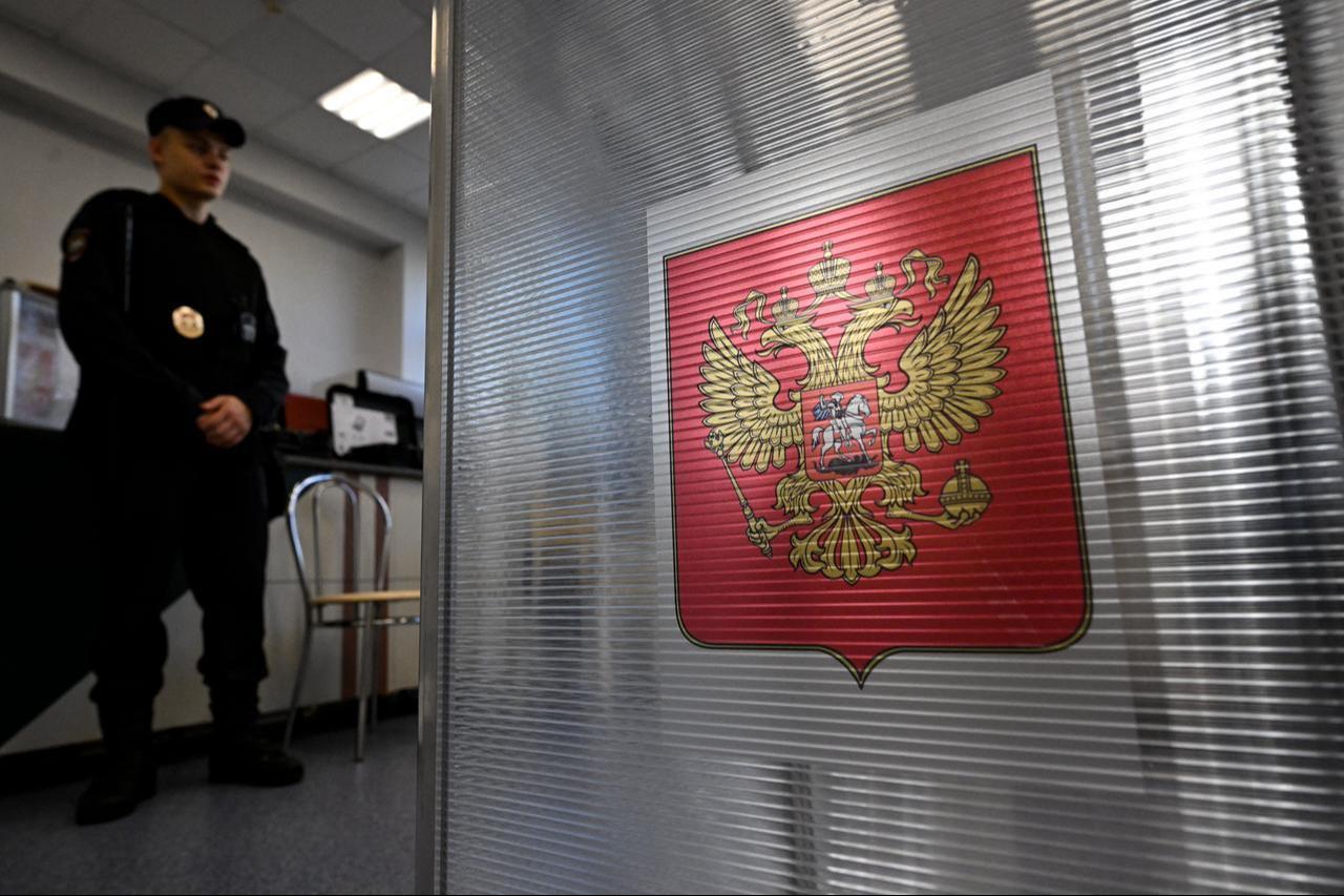 A policeman stands next to a ballot box during Russia's parliamentary election at a polling station in Moscow on September 20, 2026. (AFP Photo)