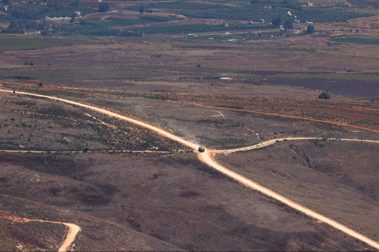 This picture taken from a position in the Upper Galilee region in northern Israel shows an Israeli military vehicle driving along a road in southern Lebanon on September 20, 2026. (AFP Photo)