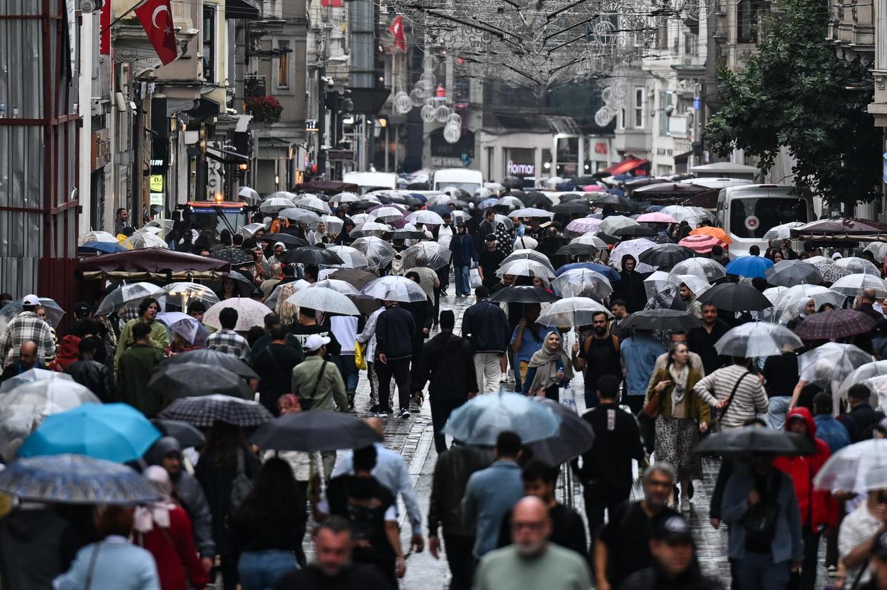Crowded Istiklal Street with pedestrians walking under umbrellas in rainy weather. (AA Photo)