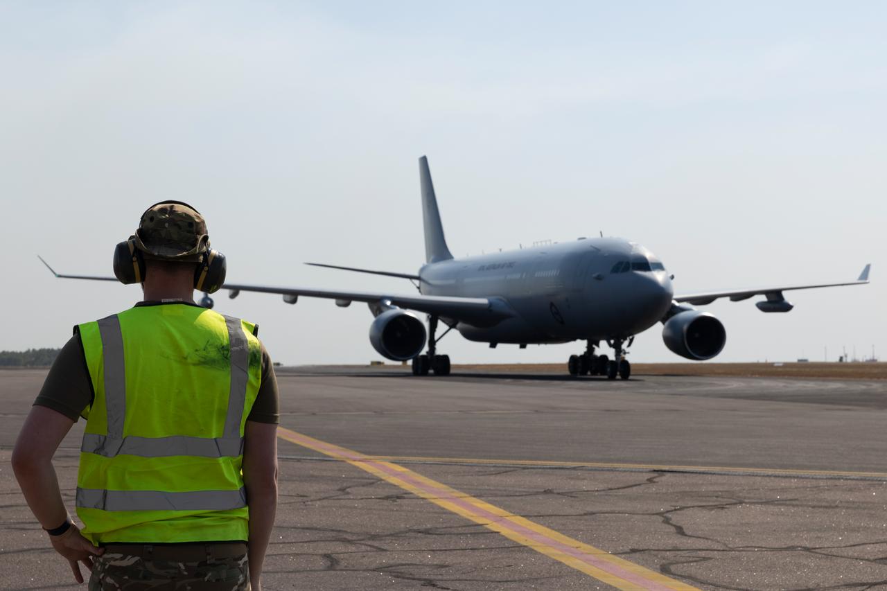 An RAF Mover waiting to walk along the edge of the wingtips of a Royal Australian Air Force Voyager to provide the pilots with confirmation that the wings are not going to hit any obstacles. (UK MOD © Crown copyright 2026)