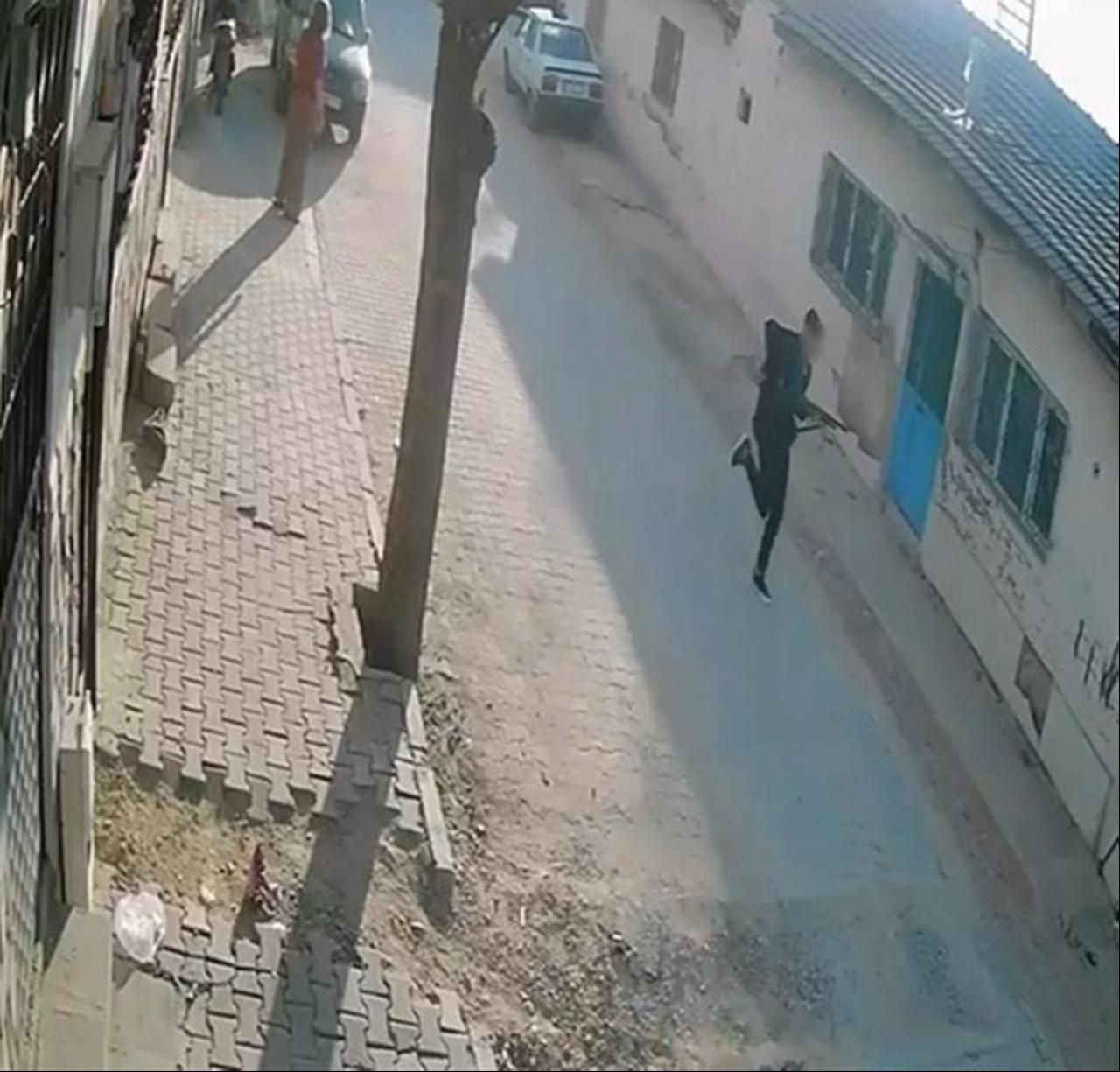 A security camera image shows the suspected attacker carrying a shotgun along a street near the school in Turgutlu, Manisa, Türkiye. (IHA Photo)