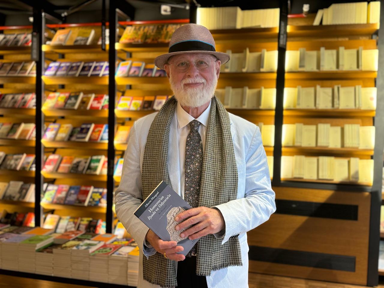 Writer, translator and literary scholar Alberto Manguel poses with his book Homer’s Iliad and Odyssey: A Biography during an event in Istanbul, Türkiye, Sept. 23, 2026. (AA Photo)