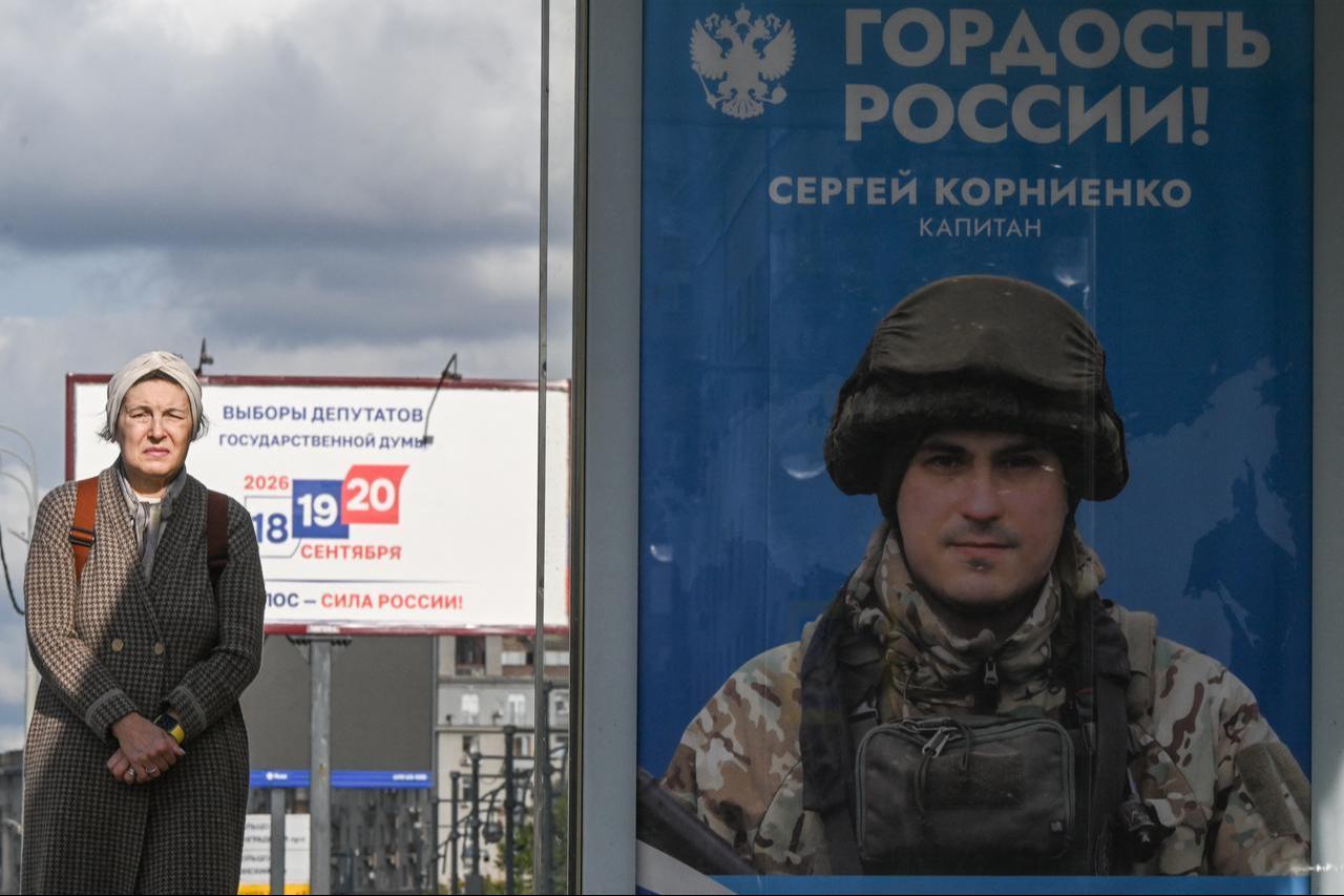 A woman stands next to a poster honoring a participant in Russia's military action in Ukraine and reading "Pride of Russia!" in Moscow on Sept. 15, 2026. (AFP Photo)