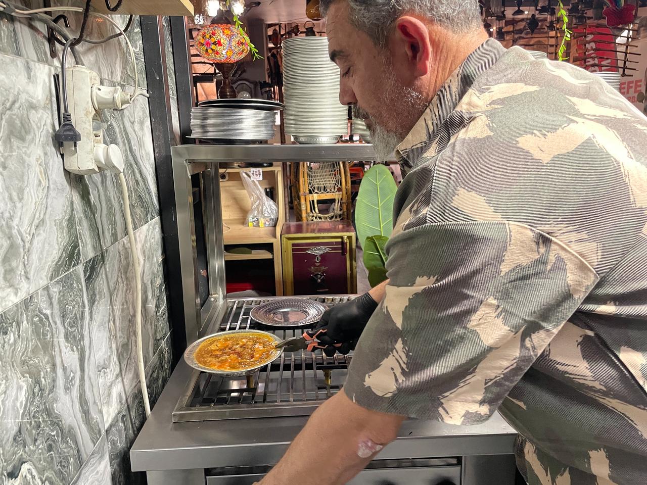 Soup restaurant owner Ramazan Bademci prepares a serving of "atom" over the stove in Konya, Türkiye. (IHA Photo)