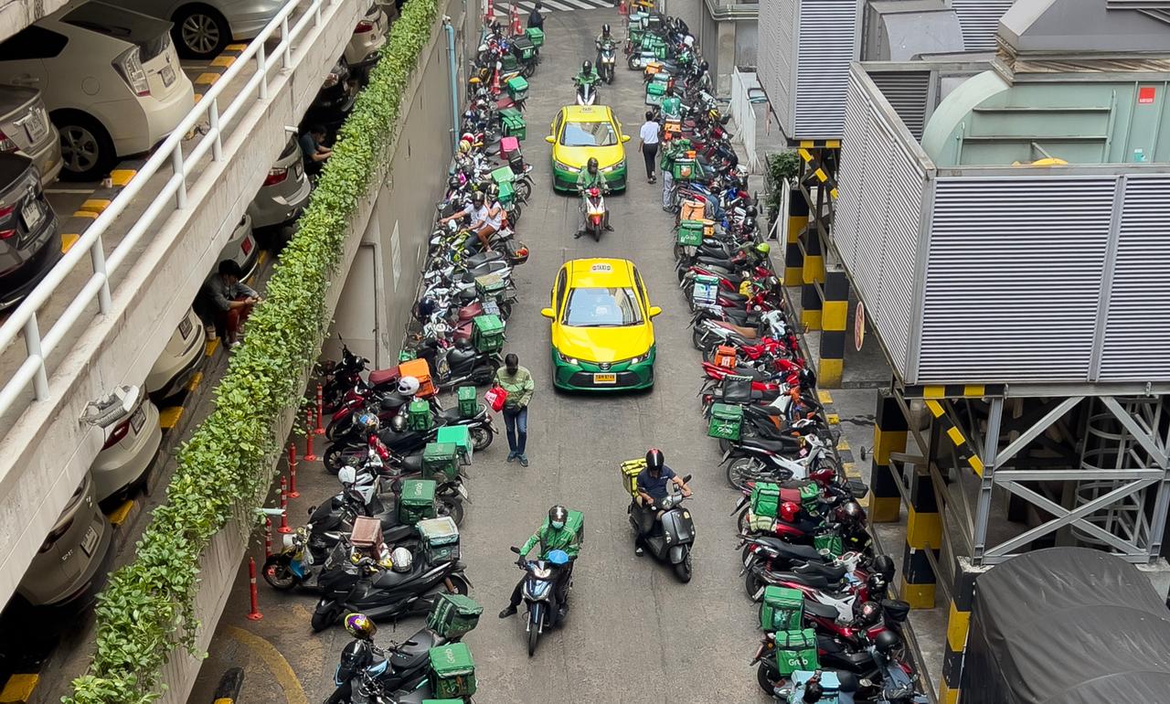 Food-delivery motorcycles line a busy service area alongside taxis, illustrating the growth of app-based delivery services. (Adobe Stock Photo)