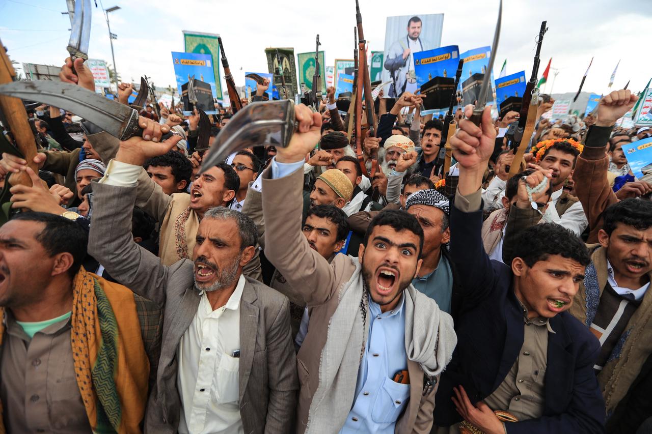 Supporters of the Houthi authorities brandish their weapons and hold placards showing the Kaaba and reading "For it, we willingly offer our souls" during a protest against the Saudi intervention in Yemen and against Saudi Arabia's recent accusation that the Houthis fired at the holy city of Mecca, in Sanaa, September 18, 2026. (AFP Photo)