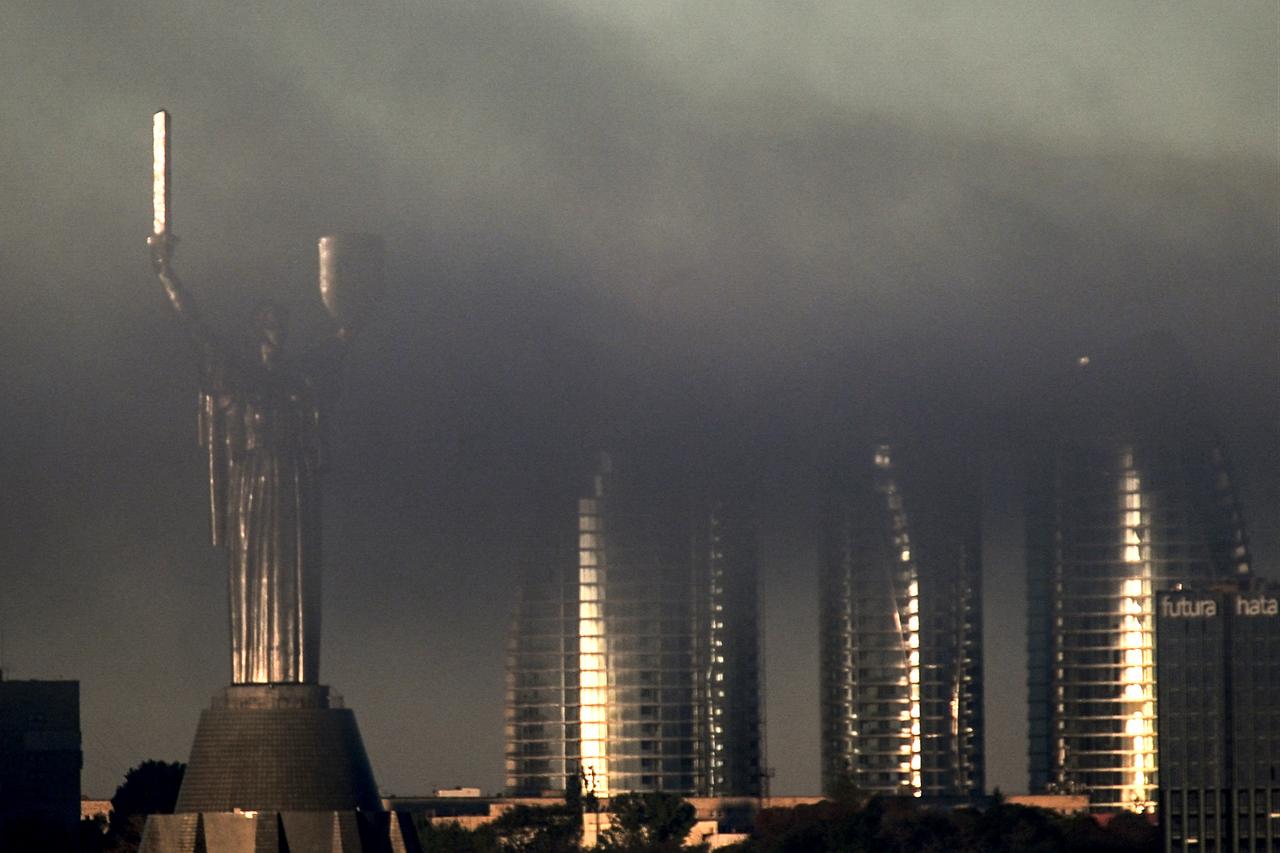 The Motherland Monument (L) and the Taryan Towers are seen through smoke rising above the city following an air attack in Kyiv on September 23, 2026. (AFP Photo)