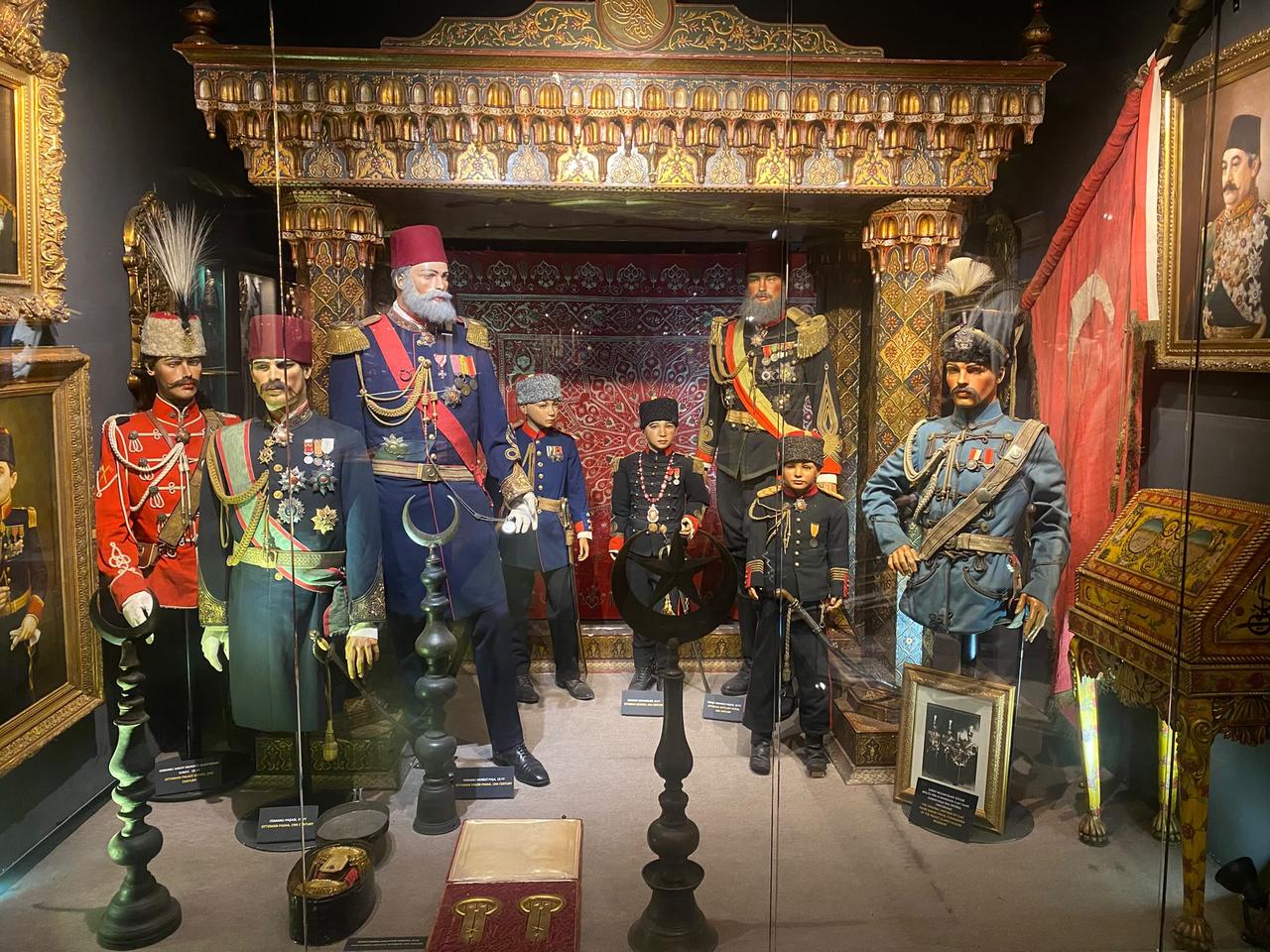 High-ranking Ottoman military figures and royal officials against an ornate gilded imperial canopy background. (Photo via Türkiye Today team/ Feiza Jdidi)
