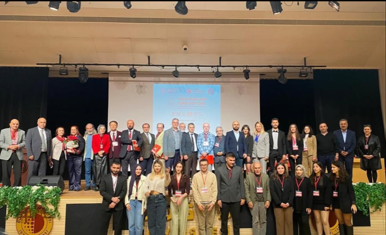 Participants and organizers pose for a group photo during the “Copyright Symposium" at a university auditorium in Türkiye. (Photo via social media/@telifhaklarisempozyumu)