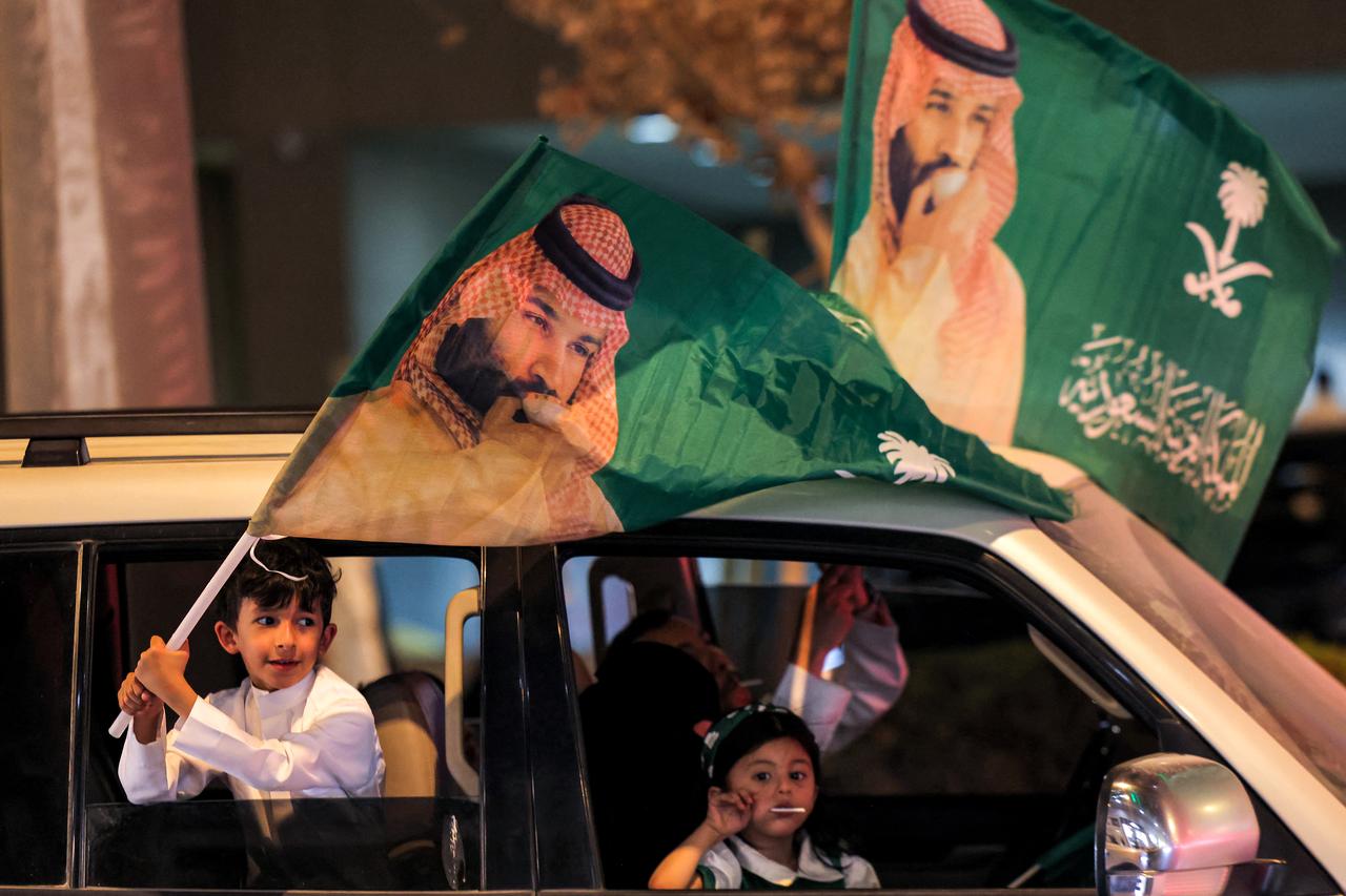 A child waves a flag bearing the image of Saudi Arabia's Crown Prince Mohammed bin Salman from a vehicle during the 96th Saudi National Day celebrations in Riyadh on September 23, 2026. (AFP Photo)