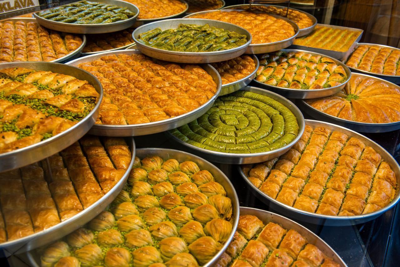 The photo shows Turkish baklava varieties on trays in a dessert store at an unspecified location and time. (Adobe Stock Photo)