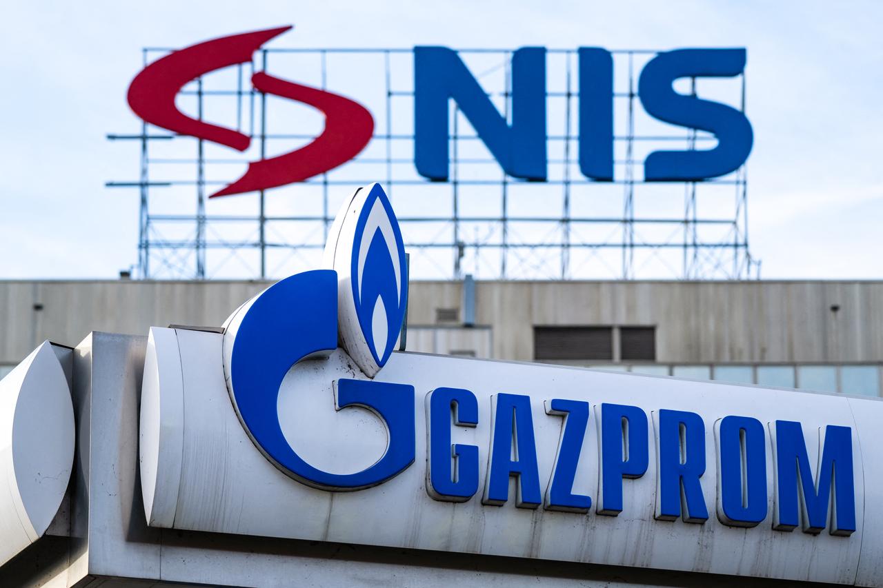 This photograph shows the logo of the Naftna Industrija Srbije - NIS (Petroleum Industry of Serbia) is displayed on the facade of the company's headquarters above the logo of  a Gazprom gas station in Belgrade on November 25, 2025. (AFP Photo)