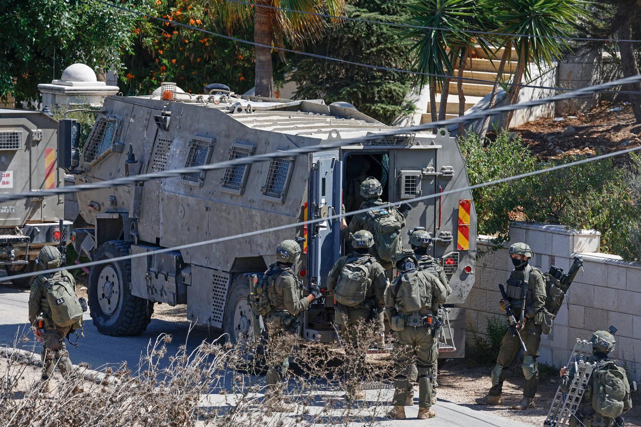 Israeli soldiers board a vehicle after conducting a raid in the Palestinian village of Biddu, northwest of Jerusalem on September 21, 2026. (AFP Photo)