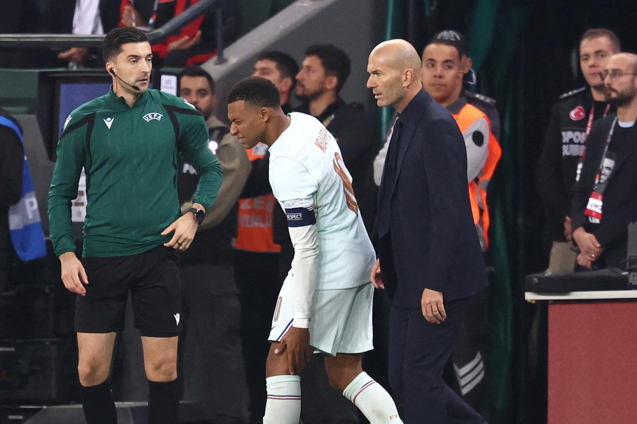 Mbappe (C) reacts after picking up an injury after his team's first goal, next to France's head coach, Zinedine Zidane, during the UEFA Nations League match against Türkiye. (AFP Photo)