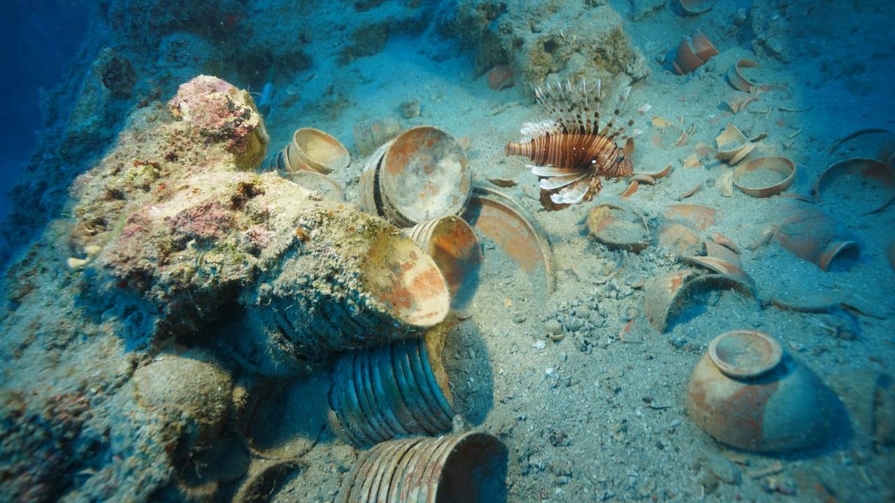 Ancient ceramic plates and bowls lie scattered across the seabed at the 2,100-year-old shipwreck site off Adrasan, as a lionfish swims above the remains. (AA Photo)
