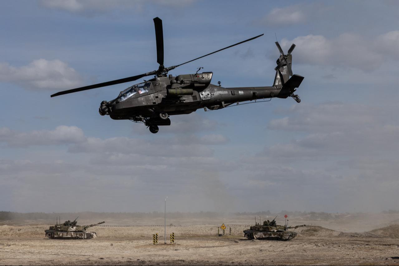 A Polish Air Forces US-made AH-6h Apache helicopter flies during a demonstration of Polish Army training at the military training ground in Nowa Deba, Poland, Sept. 7, 2026. (AFP Photo)