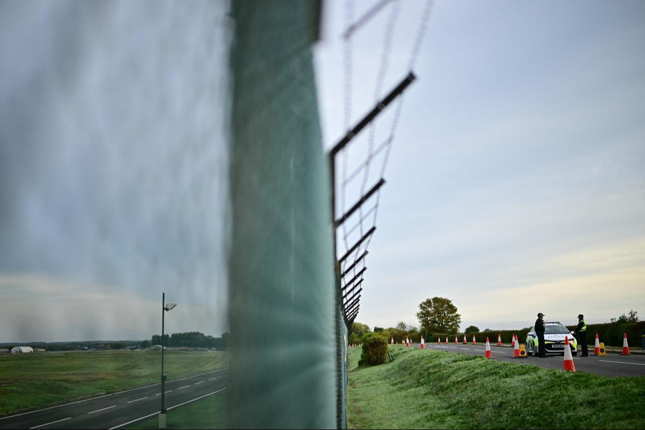Police (R) continue to man a roadblock outside RAF Fairford base (L) in Fairford, south-west England on September 28, 2026. (AFP Photo)
