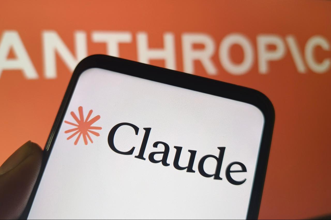The Claude logo is displayed on a smartphone with Anthropic branding in the background. (Adobe Stock Photo)