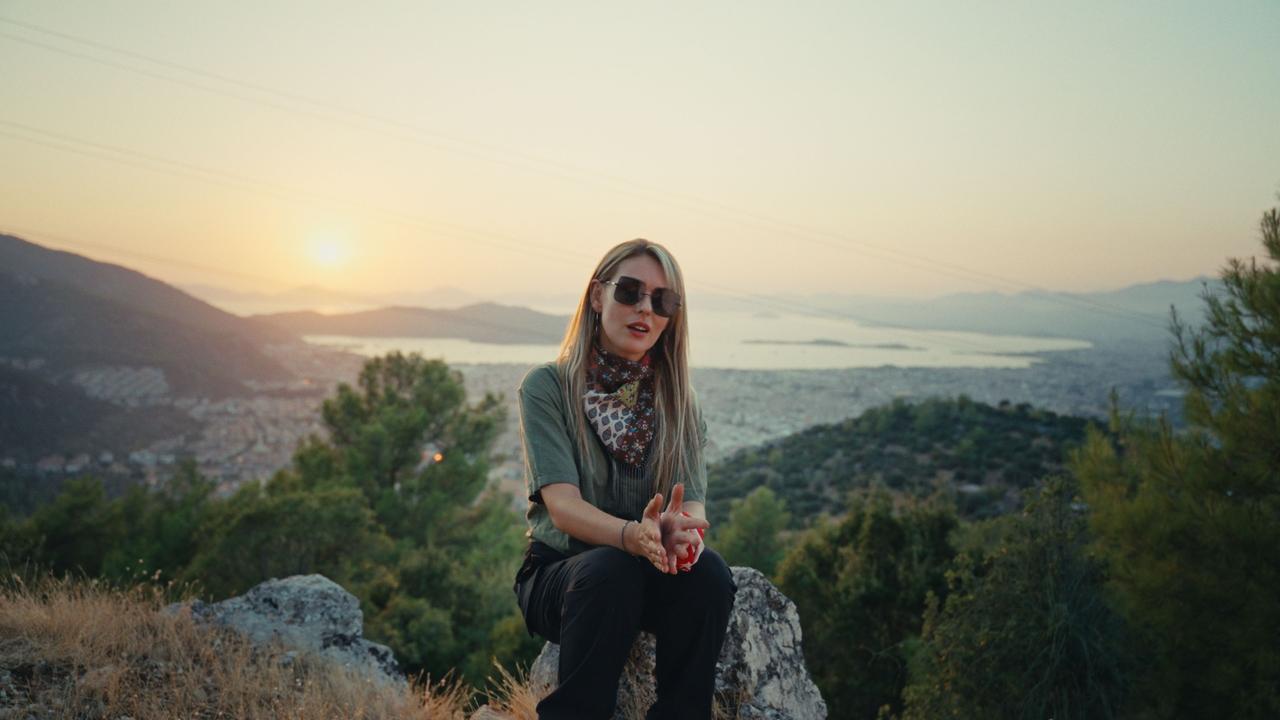 Asst. Prof. Irem Albayraktaroglu Goktas, head of the Telebehi Archaeological Survey, speaks at the research area overlooking Fethiye in Mugla, southwestern Türkiye. (Photo via Telebehi Archaeological Survey Project)