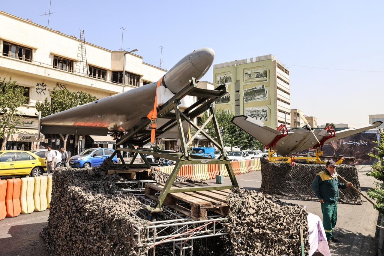 A municipal employee stands next to military drones on display at Baharestan Square in Tehran on September 28, 2026. (AFP Photo)