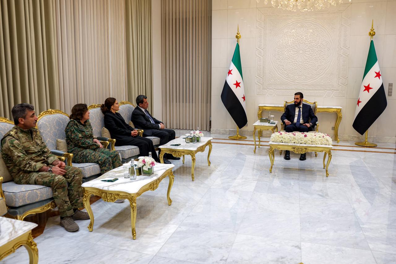 Syria's president Ahmed al-Sharaa (R) attends a meeting with his foreign minister (not pictured) and Mazloum Abdi (4th-L.) (AFP Photo)