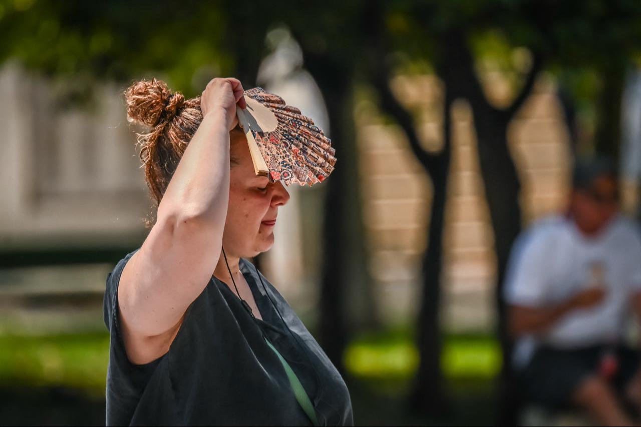 A woman shields herself from the sun with a hand fan during a heat wave in Athens, Greece, July 21, 2026. (AFP Photo)