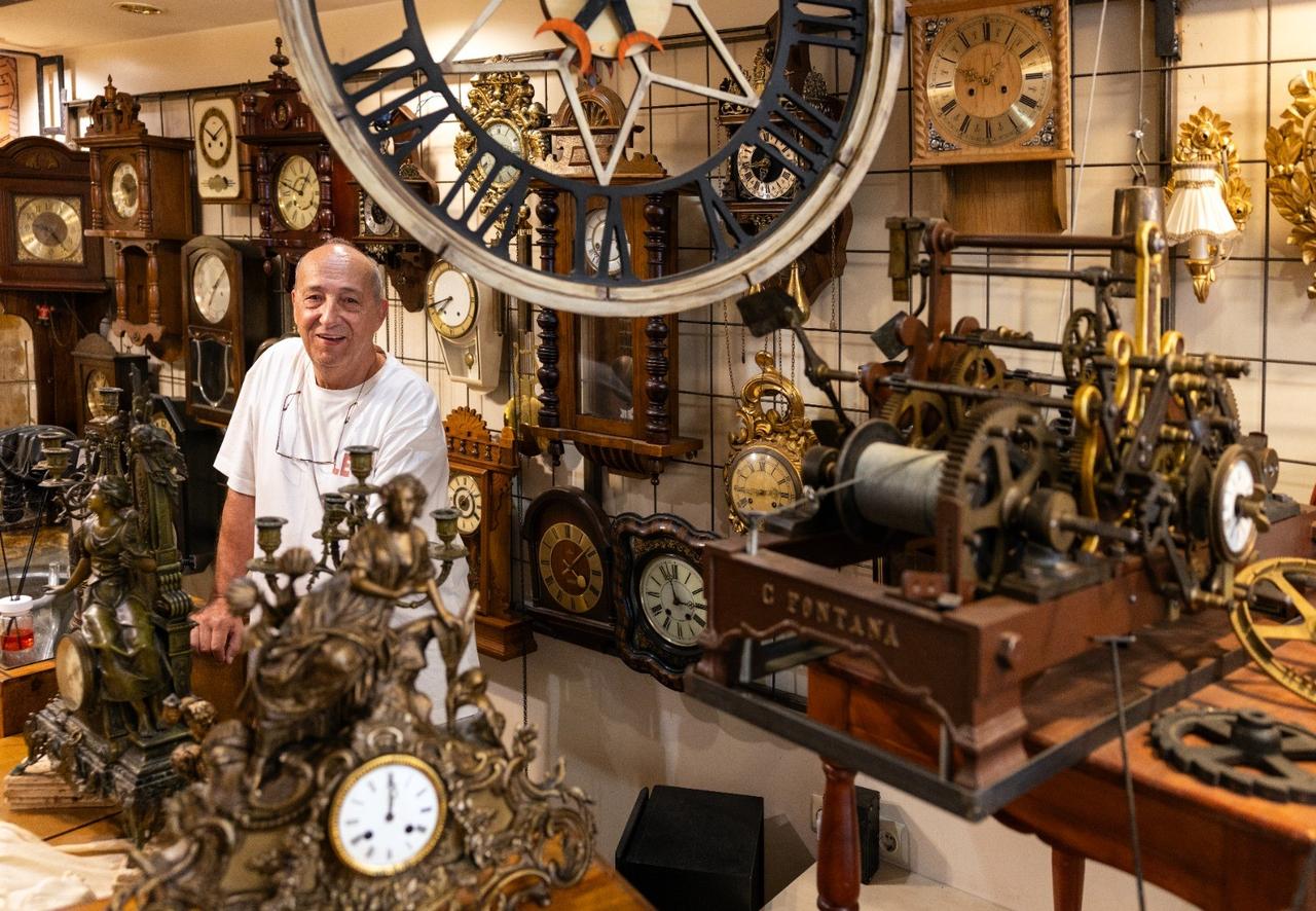Feti Pamukoglu, a 68-year-old clockmaker who has been maintaining the clock since 1994, posing between his clocks. (AA Photo)