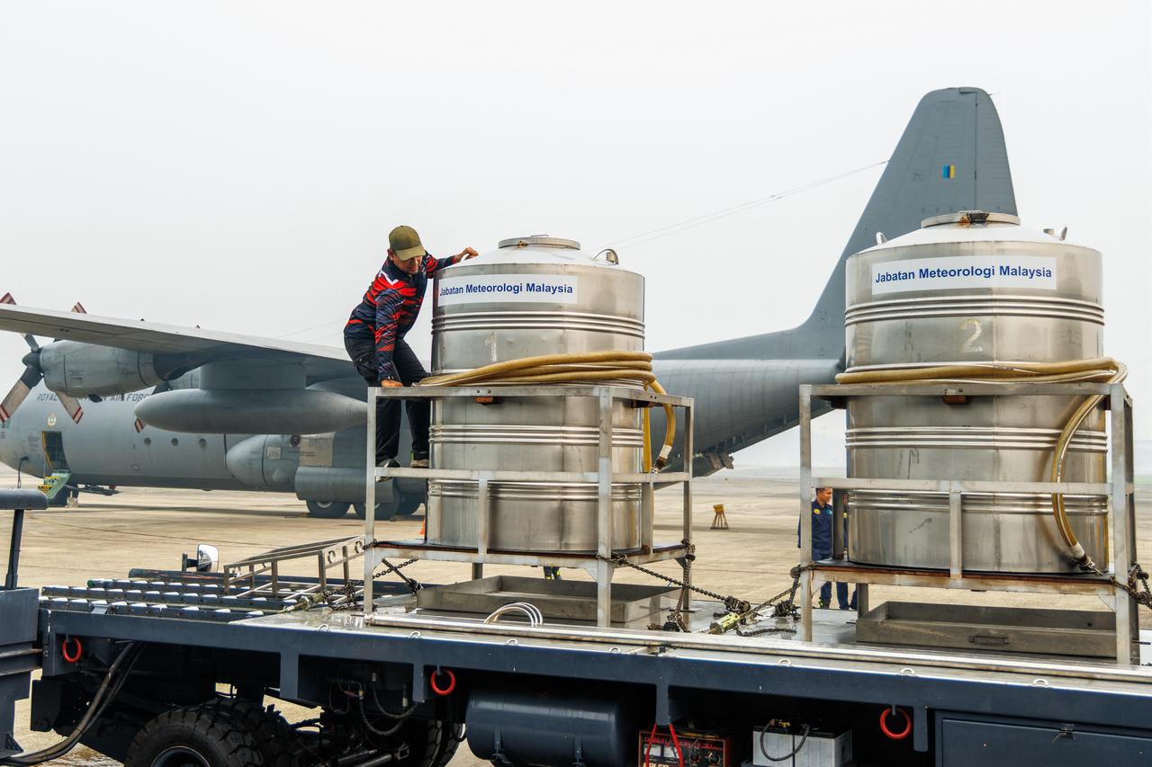 Man prepares cloud-seeding tanks before they are loaded onto a Royal Malaysian Air Force C-130 aircraft at the air force base in Kuching, on September 3, 2026. (AFP Photo)