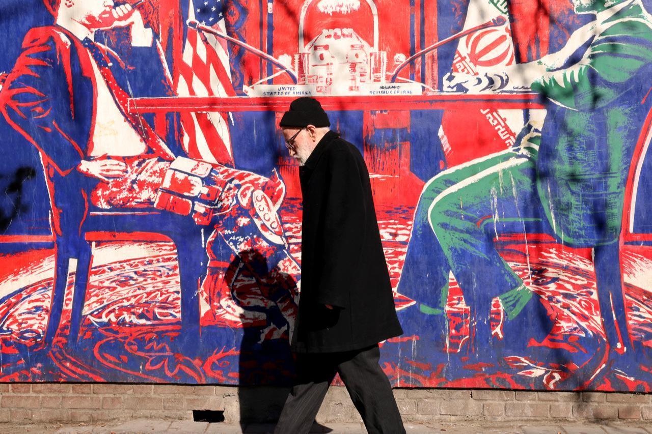 A man walks past a mural painted on the outer walls of the former US embassy in Tehran, colloquially-referred to as the "Spy Den," on Feb. 1, 2026. (AFP Photo)