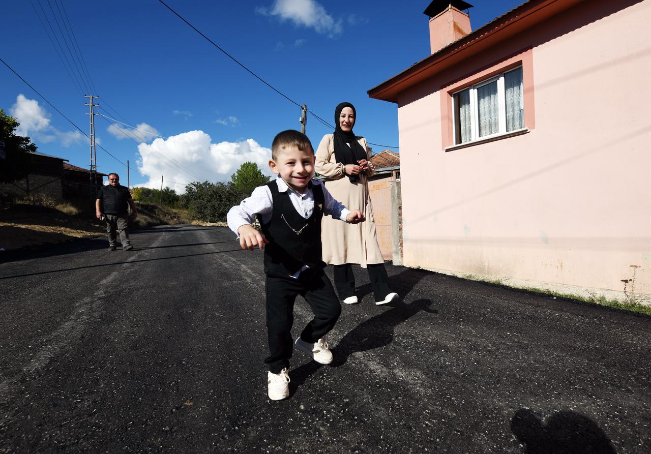 Nurten Kilicoglu watches her son, Kursat, walk independently on the newly paved village road in Doguorcunler, Türkiye. (AA Photo)
