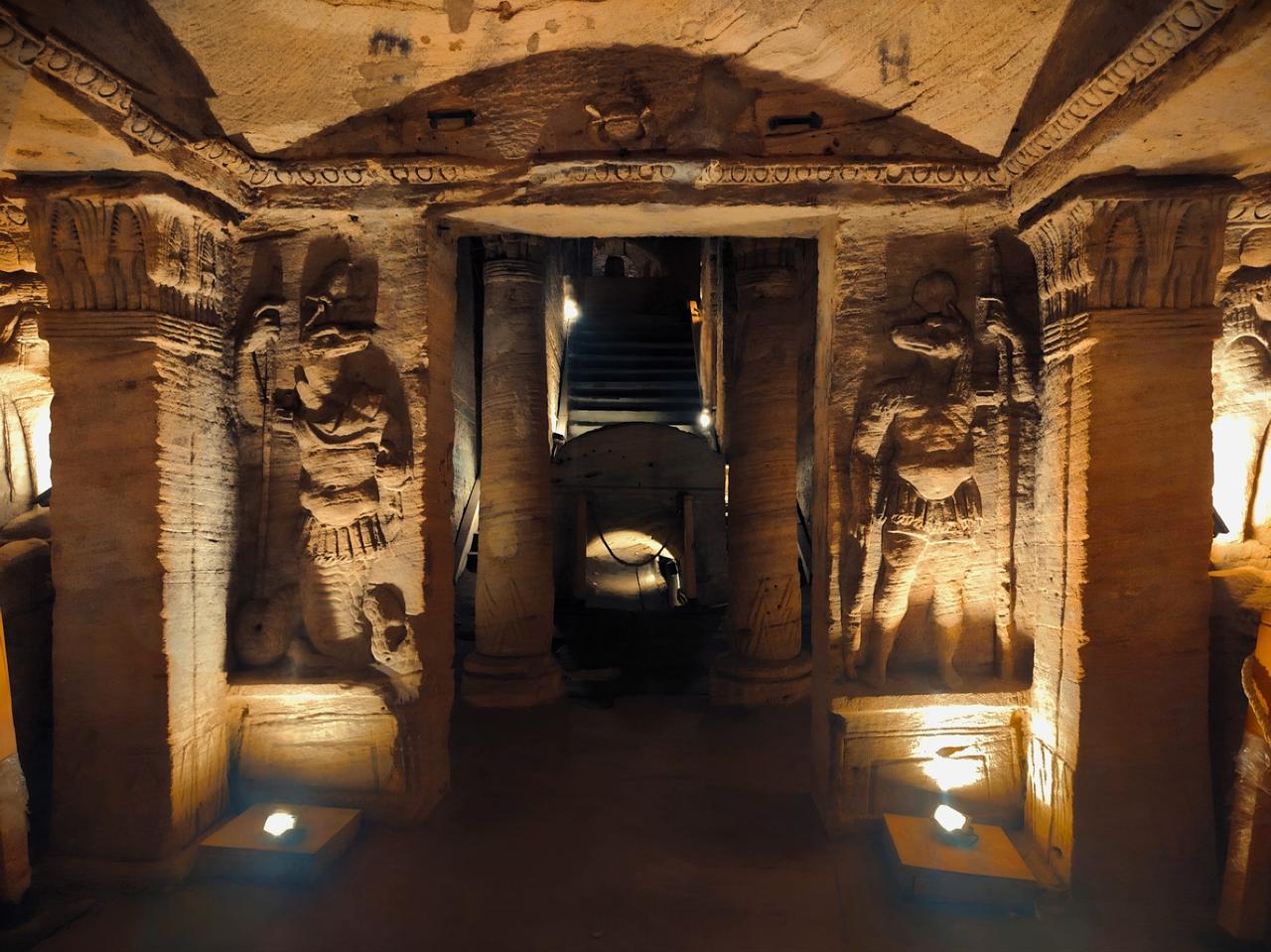 Ancient reliefs and columns line the underground passages of the Catacombs of Kom El Shoqafa, where Egyptian and Roman funerary traditions come together. (Photo via Wikimedia)