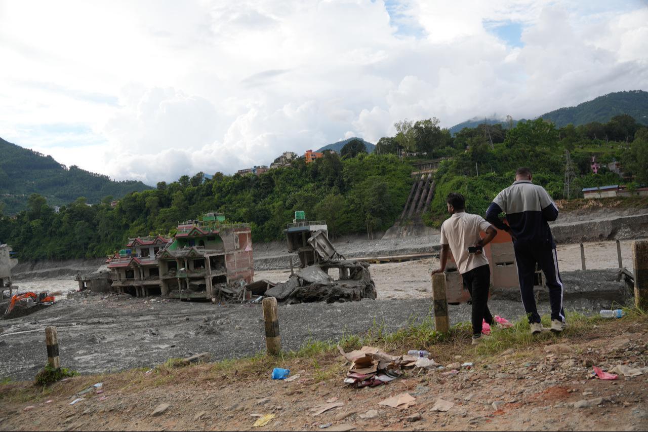 Residents stand among belongings and debris outside a flood-damaged building in Nuwakot, Nepal, Sept. 1, 2026. (AA Photo)
