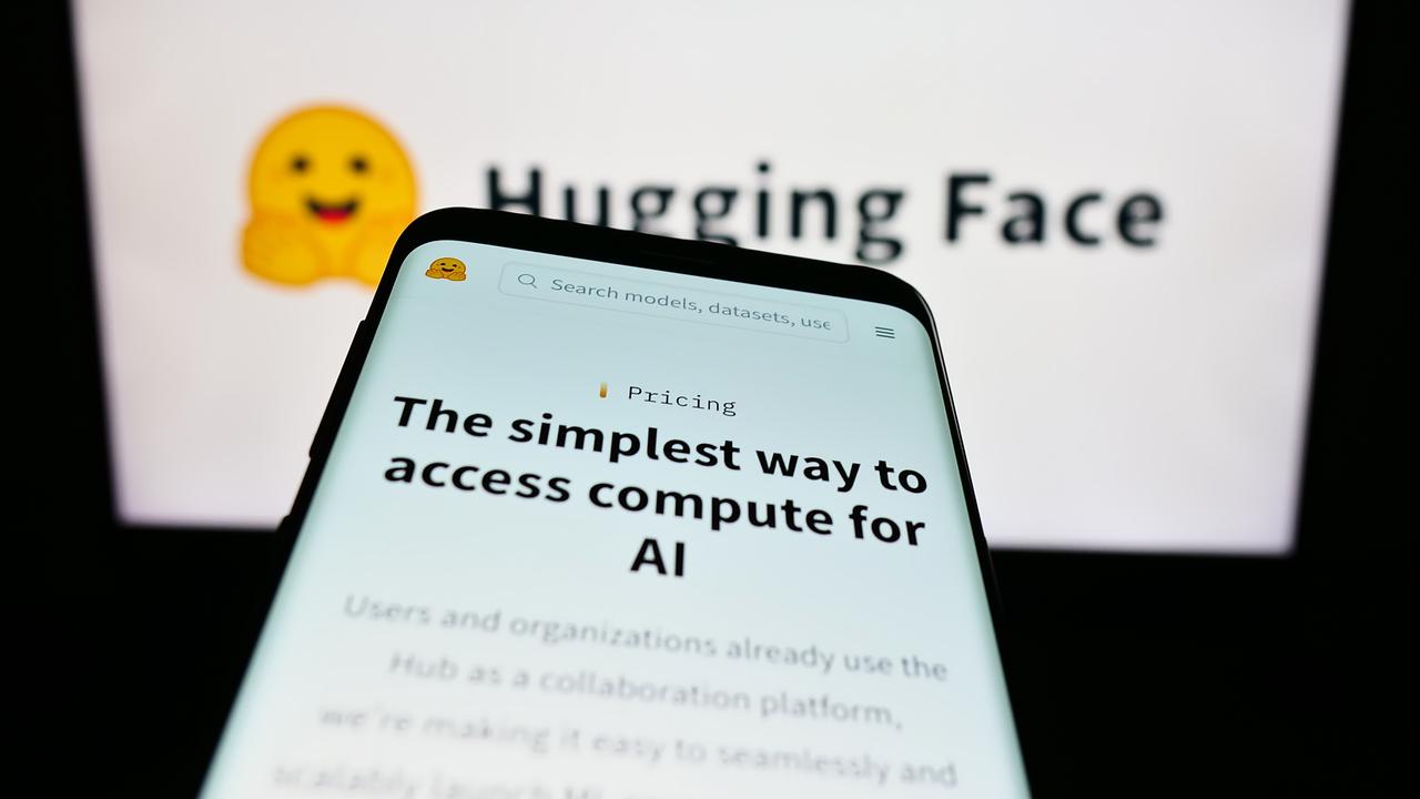 Hugging Face’s website is displayed on a smartphone in front of the company’s logo. (Adobe Stock Photo)