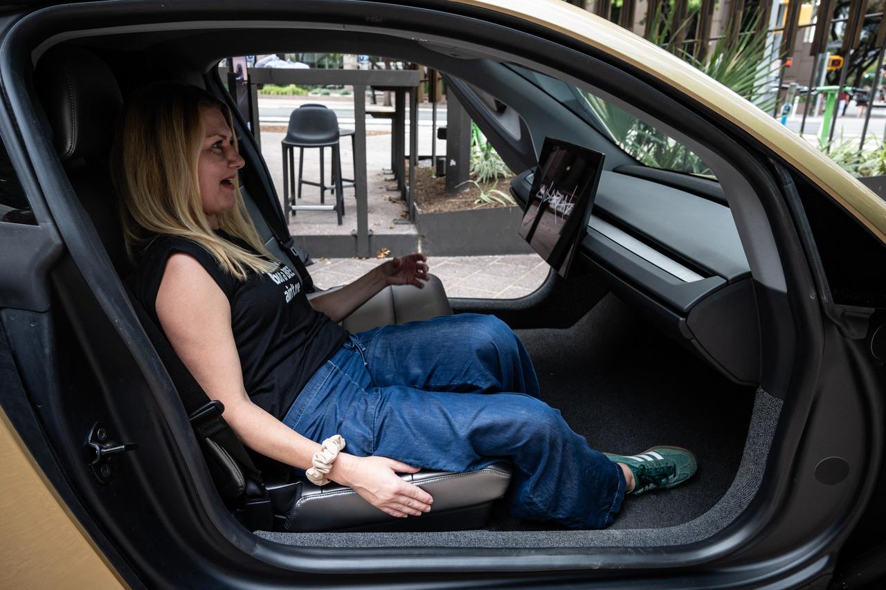 Woman sits inside Tesla's "Cybercab" as it's displayed in downtown Austin, Texas, on September 3, 2026.(AFP Photo)