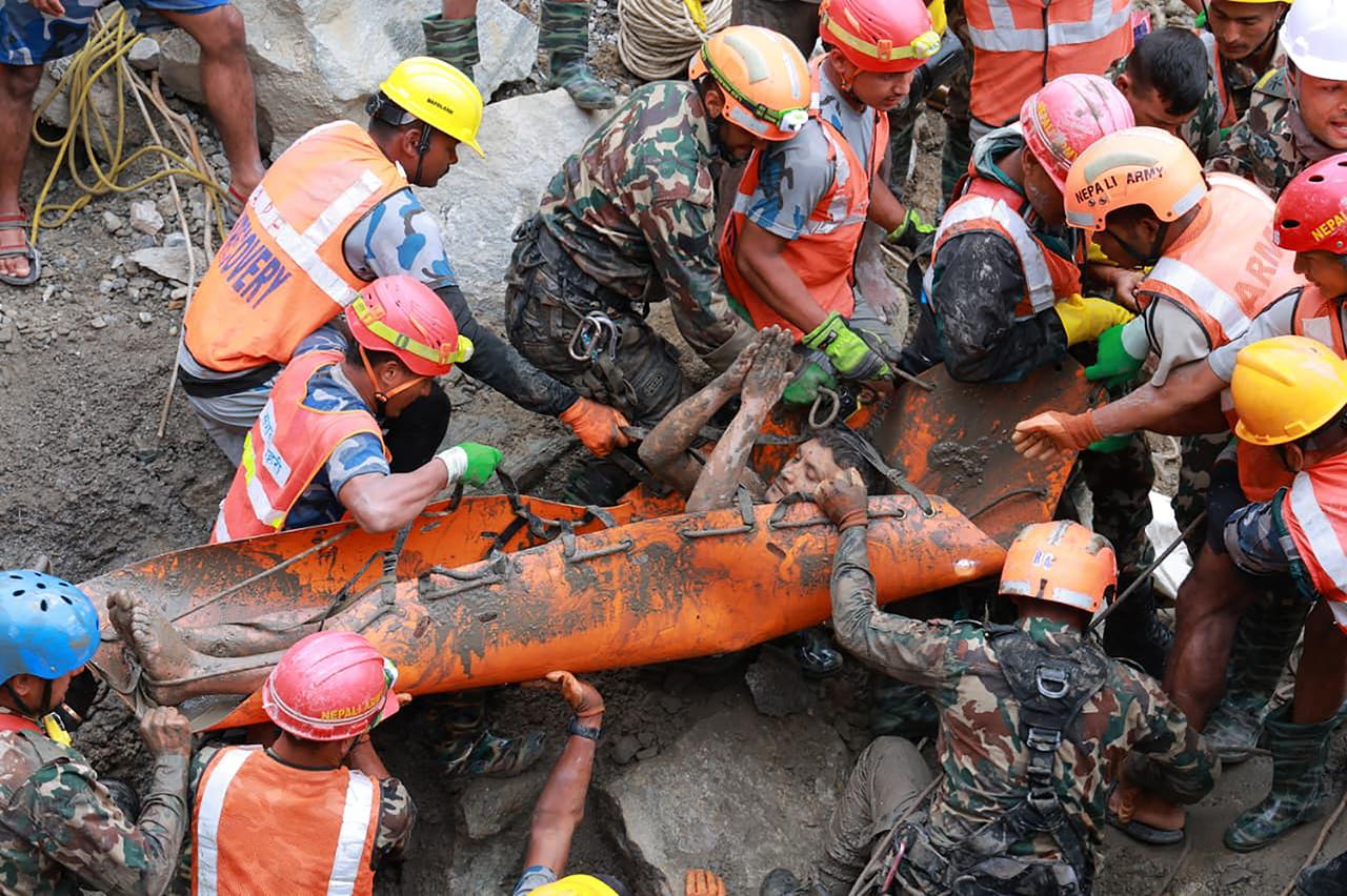 Rescue workers pull a survivor from debris after destructive flooding and landslides in Nepal, Sept. 4, 2026. (AFP Photo)