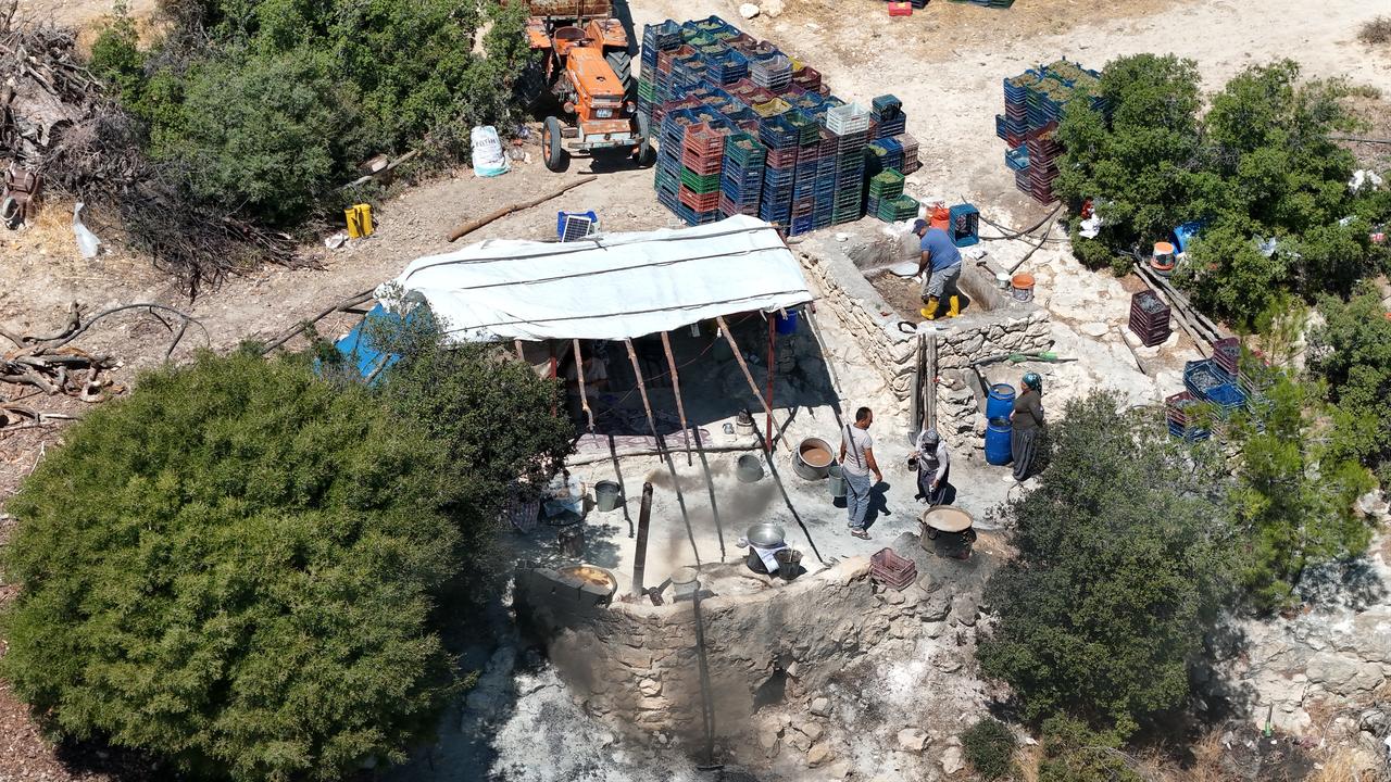 An aerial view shows villagers preparing pekmez, a traditional grape molasses, at a "sihrana" cooking site in the Alacam neighborhood of Mersin's Mut district.(AA Photo)