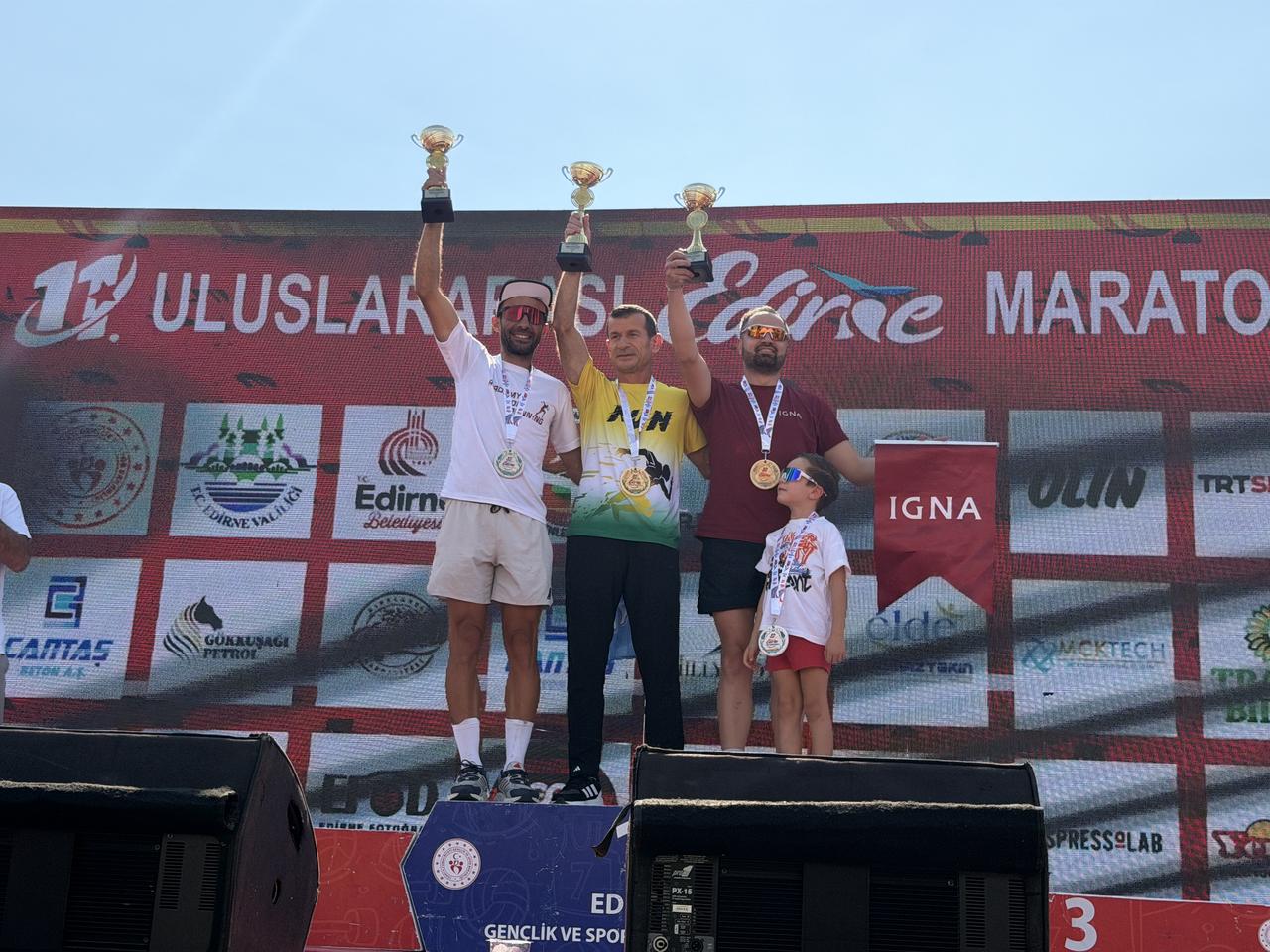 Top-placing runners celebrate on the podium with their trophies and medals at the conclusion of the 11th International Edirne Marathon. (AA Photo)