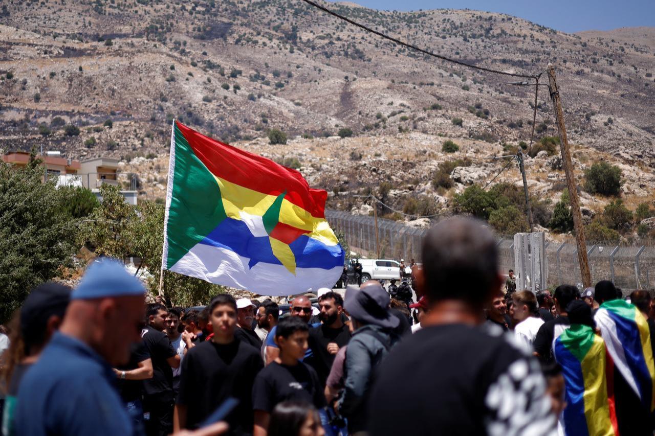 Druze wait near the border fence in the Israeli-annexed Golan Heights village of Majdal Shams, on July 17, 2025. (AFP Photo)