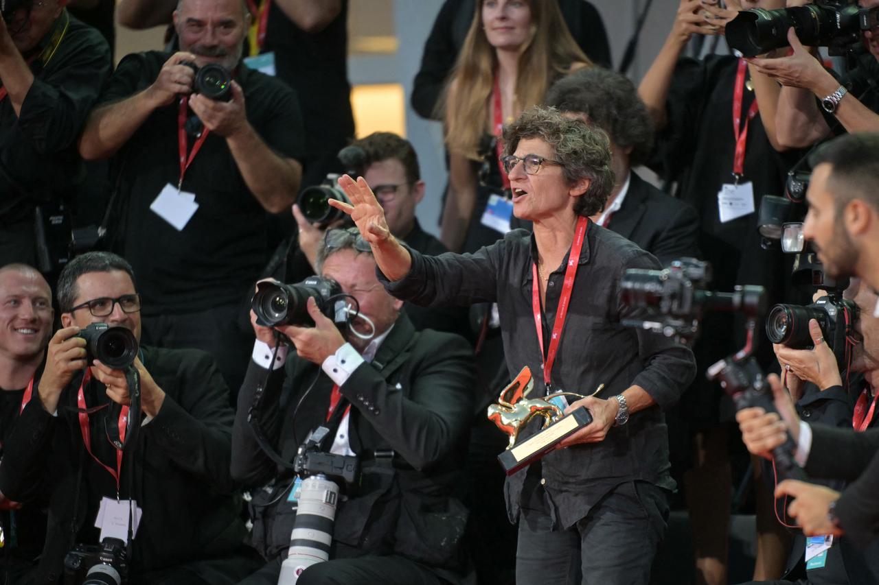 A Golden Lion recipient holds the award as photographers gather during the 83rd Venice International Film Festival in Venice, Italy, Sept. 2, 2026. (AFP Photo)