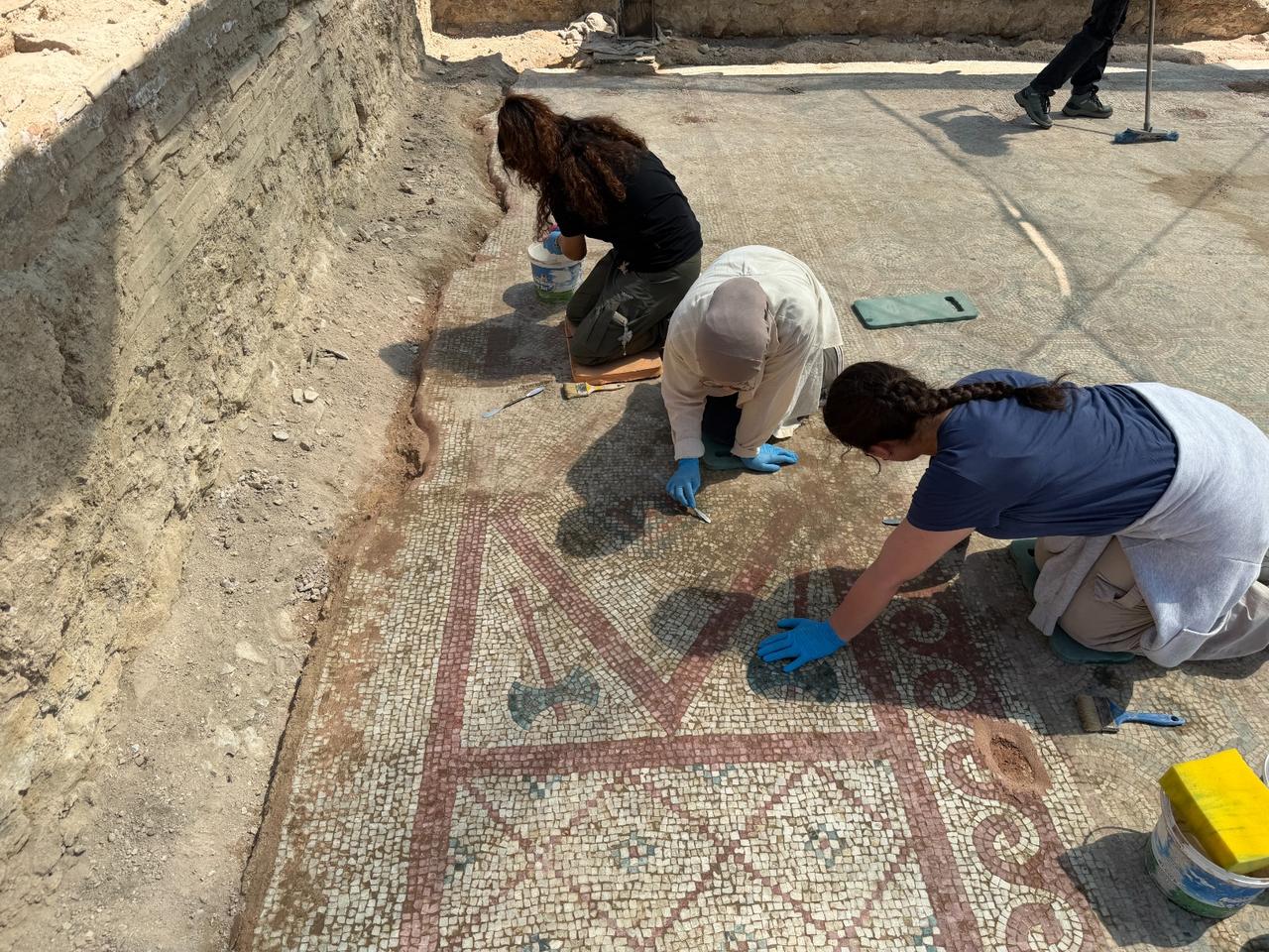 Archaeologists clean and conserve sections of the fourth-century mosaic pavement uncovered inside the Pompeiopolis basilica. (Photo via Ministry of Culture and Tourism)