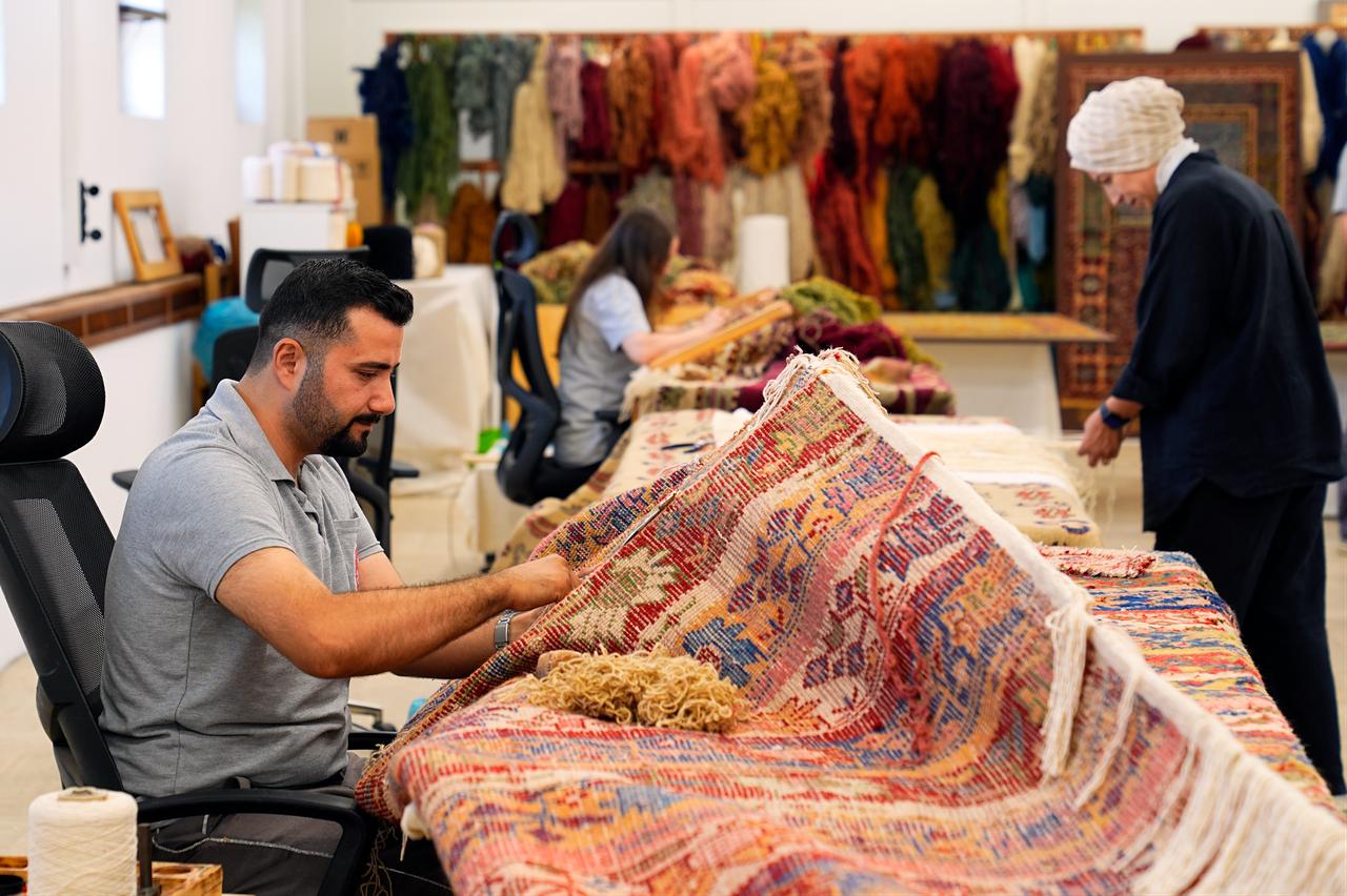 A restoration specialist works on a historic carpet as conservation efforts continue on textiles from Türkiye’s imperial palace collections. (AA Photo)