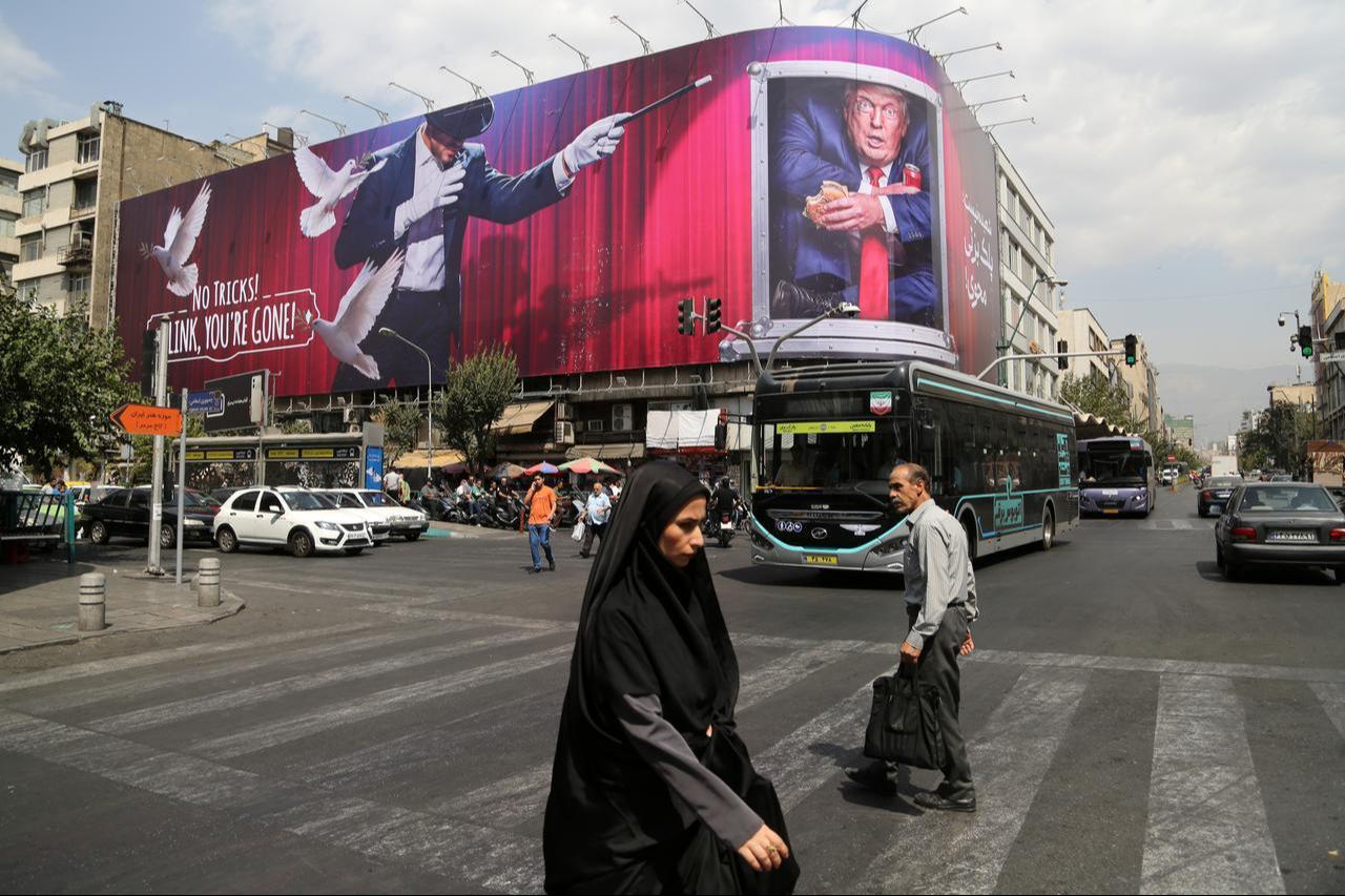 Pedestrians pass beneath a giant anti-US billboard displayed in Tehran as tensions between Iran and the United States continue on August 31, 2026, in Tehran, Iran. (AA Photo)