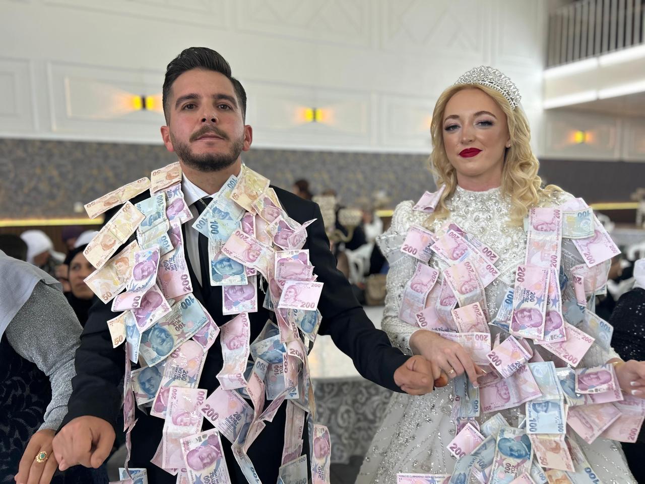 Scottish bride Leanne and Turkish groom Musa Aslan wear banknotes pinned to their clothes during their wedding celebration in Van, Türkiye, April 8, 2026. (IHA Photo)