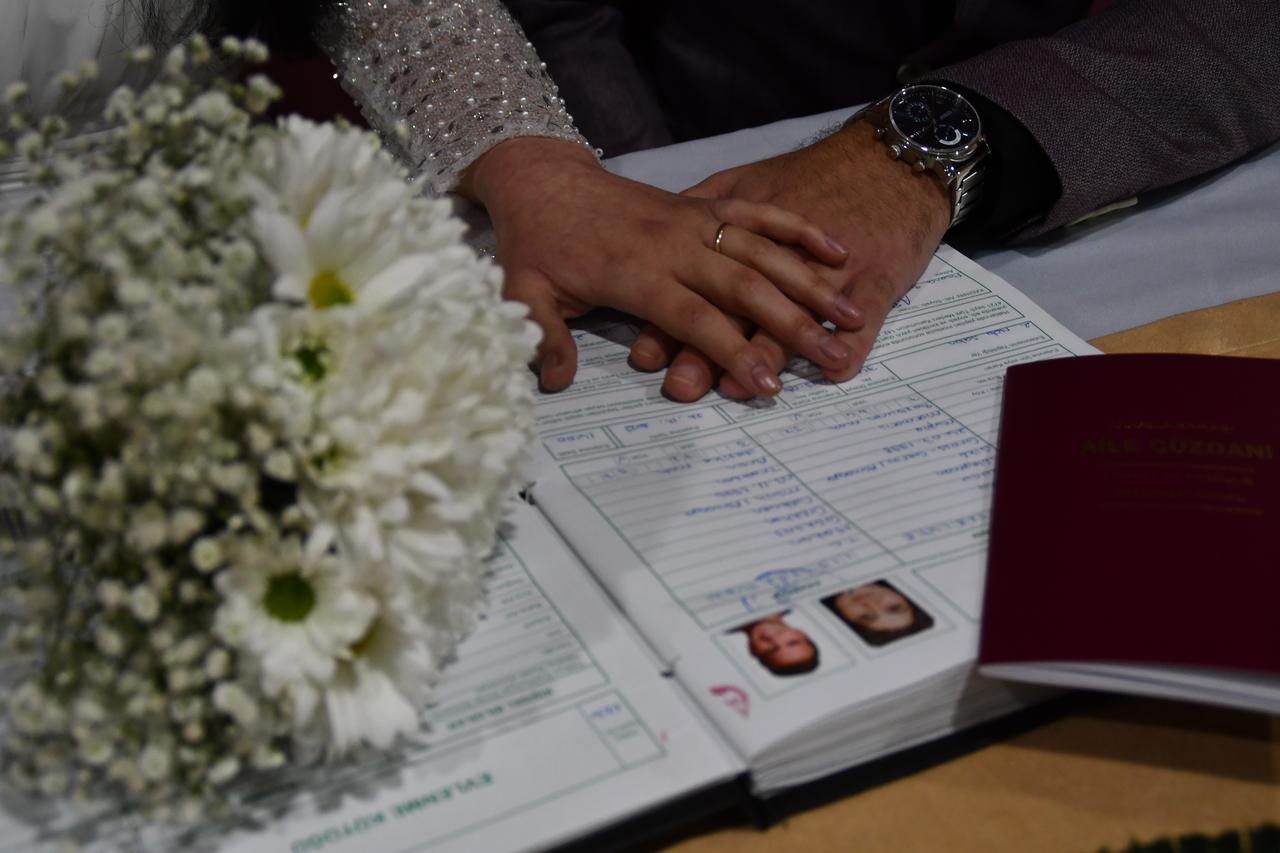 An archive photo shows a newlywed couple placing their hands over a marriage registry alongside a Turkish family booklet in Türkiye. (IHA Photo)