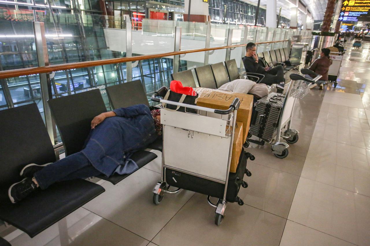 Stranded passengers rest on a bench at Soekarno-Hatta Airport in Tangerang on September 6, 2026. (AFP Photo)