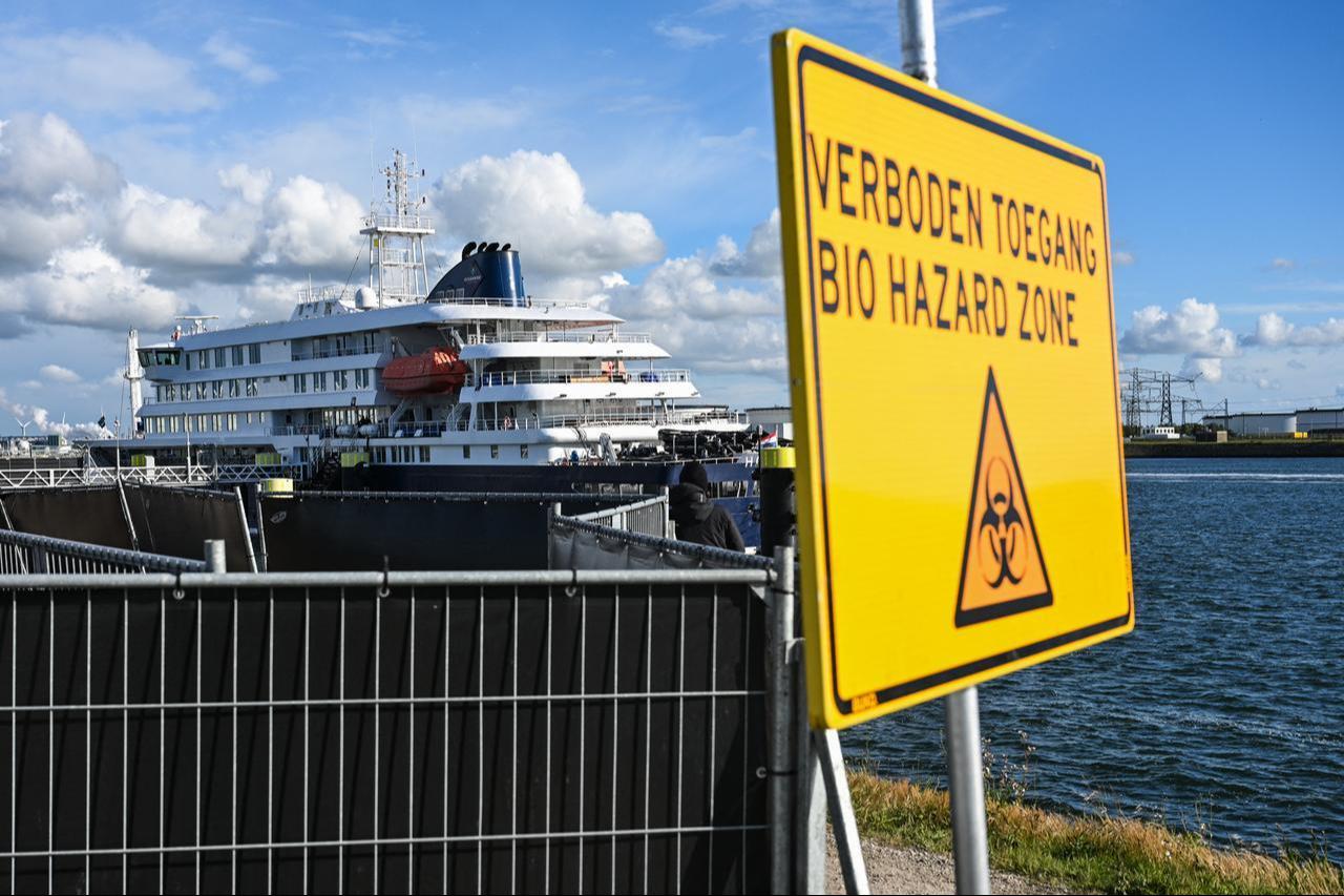 This photograph shows a view of a placard reading "Bio hazard zone" with a view of the Dutch Hantavirus-hit cruise ship MV Hondius in the background docked at the port of Rotterdam, May 18, 2026. (AFP Photo)