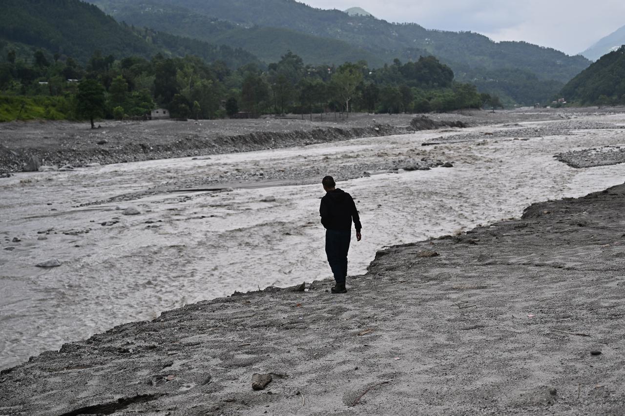 A man walks along a flood-ravaged riverbank amid widespread debris in Nepal’s Nuwakot district, Sept. 7, 2026. (AFP Photo)